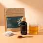 Root & Soothe Ritual: Liáo Reflux herbal syrup and Soothe+ Herbal Tea on peach